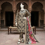 A mannequin seated on a traditional bench, wearing a black and gold paisley-patterned 3-piece unstitched lawn suit.