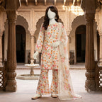 A mannequin displaying a light-toned floral printed lawn suit in a traditional architectural setting.