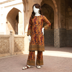 A close-up side angle view of the red and white floral unstitched lawn suit, highlighting the intricate print pattern and the detailed border on the shirt and trousers.