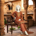 A mannequin seated on a traditional bench, showcasing the elegant combination of the geometric lawn shirt, solid trousers, and printed dupatta.