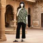 Vibrant green and black patterned baggy shirt, displayed on a mannequin in a classic outdoor setting.