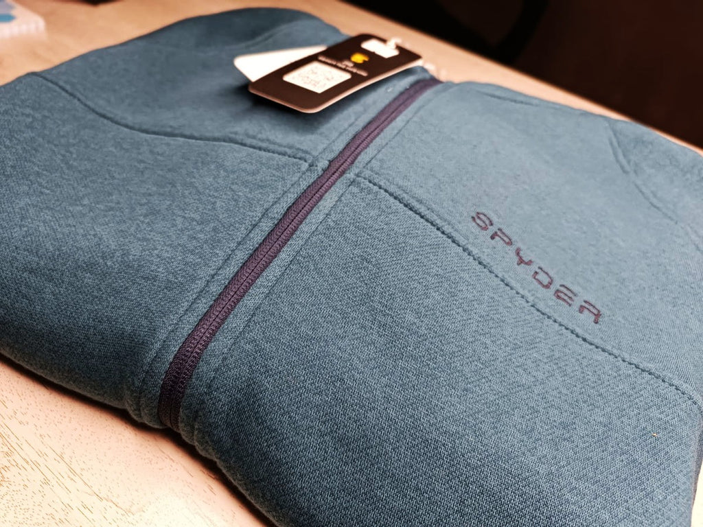 A close-up view of the premium fabric and zipper detail on the grayish blue hoodie from ZH2 Store.