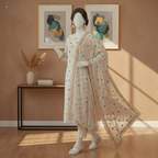 Seated view of a mannequin showcasing the intricate embroidery on the net dupatta and silk shalwar of a 3-piece suit by zh2 store.