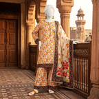 A bright and colorful floral printed 3-piece unstitched lawn suit on a mannequin, set against a traditional balcony background for the ZH2 Store collection.
