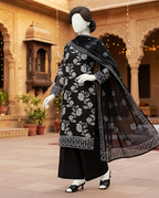 Detailed standing view of unstitched black embroidered lawn dress featuring custom daman patch and sleeves