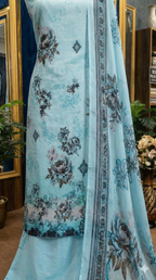 Light blue fabric with floral patterns draped over a mannequin in a room setting.
