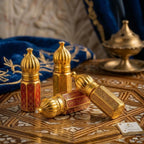 Premium gold filigree Attar bottles presented with elegant black velvet gift pouches and boxes on marble counter.